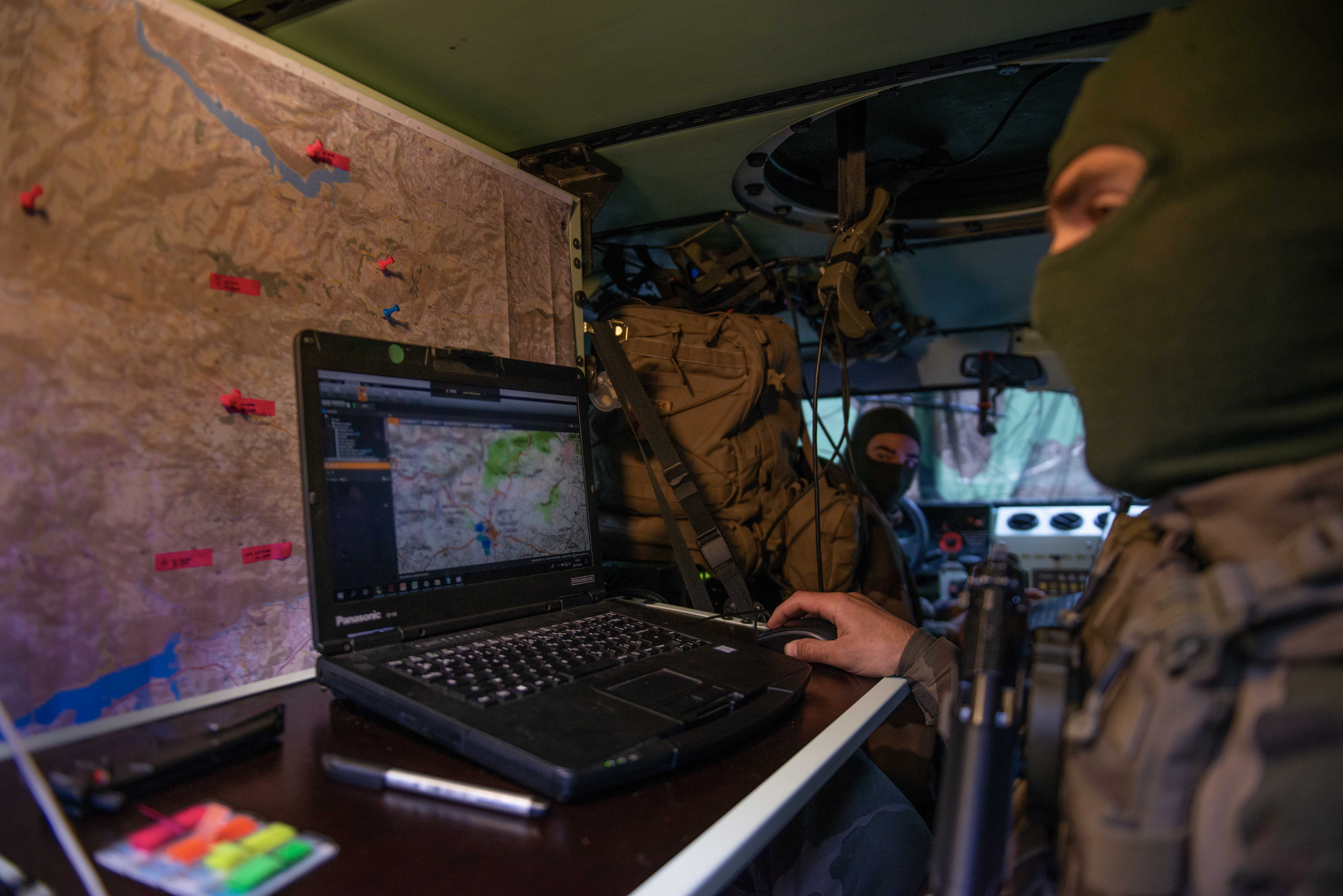 Le commandant du détachement planifie la manœuvre de ses capteurs depuis son petit véhicule protégé.