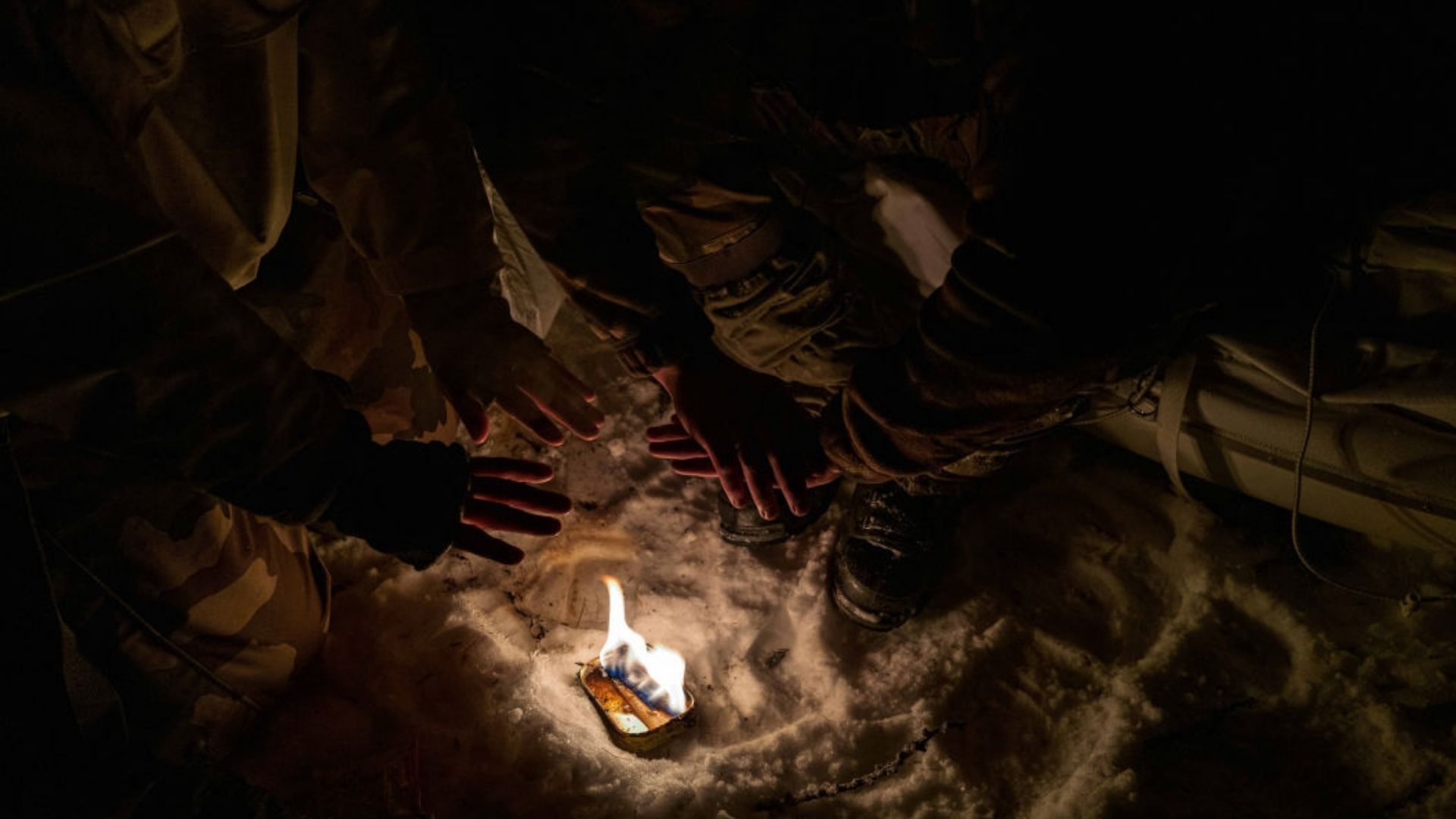 Deux fantassins se réchauffent les mains autour d'un feu improvisé.