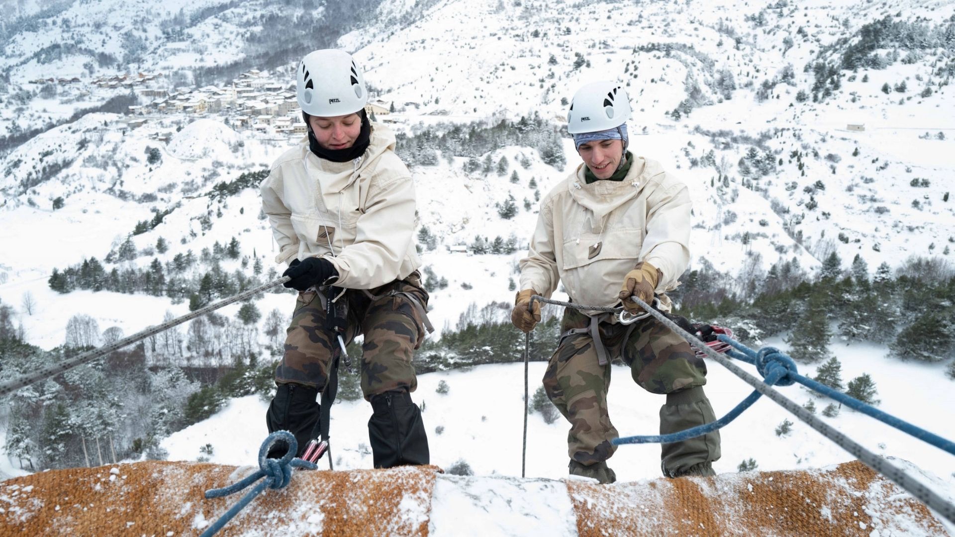 Deux stagiaires s'apprêtent à descendre une paroi rocheuse de 30 mètres, en rappel.