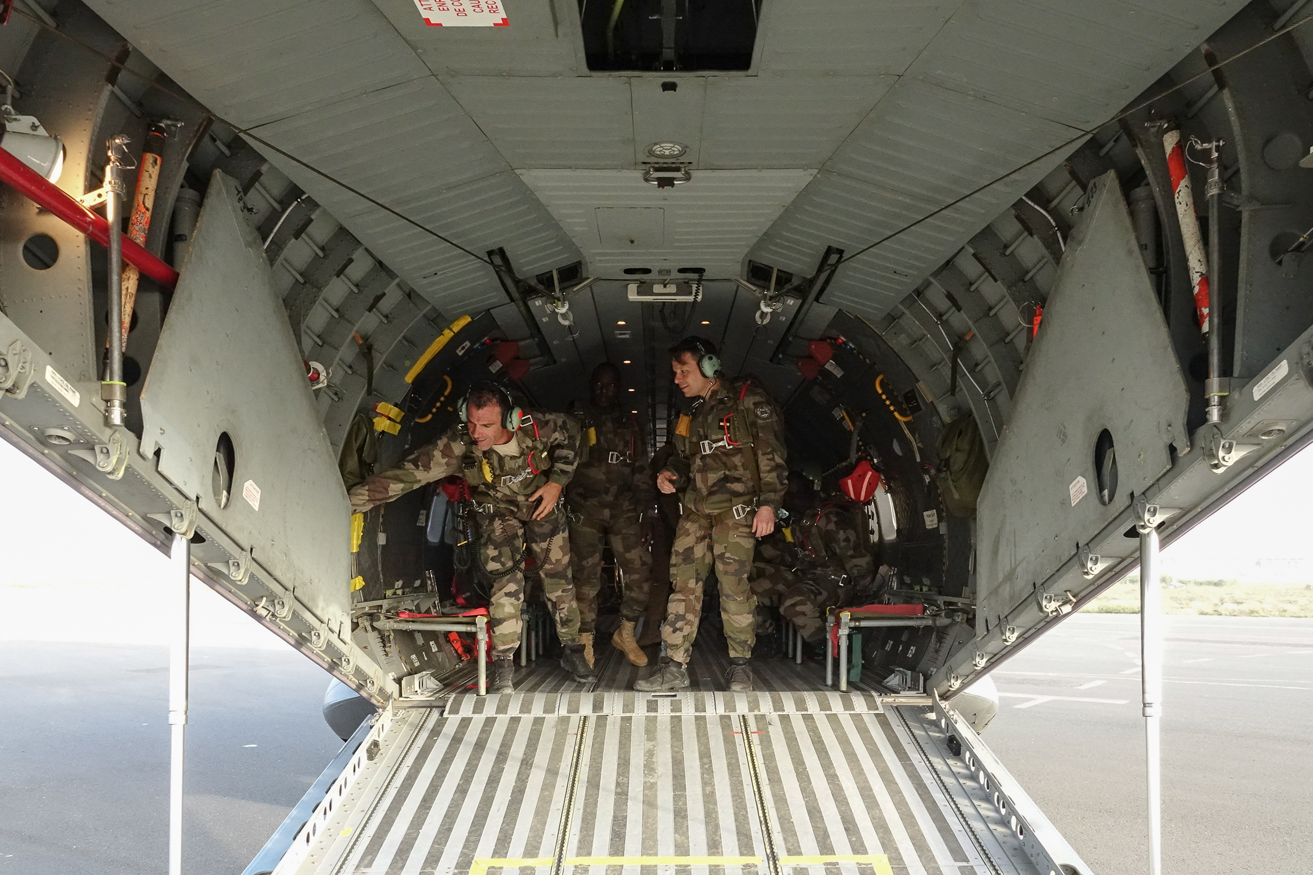 Les largueurs inspectent les équipements dans la soute de l’avion avant une séance de saut.