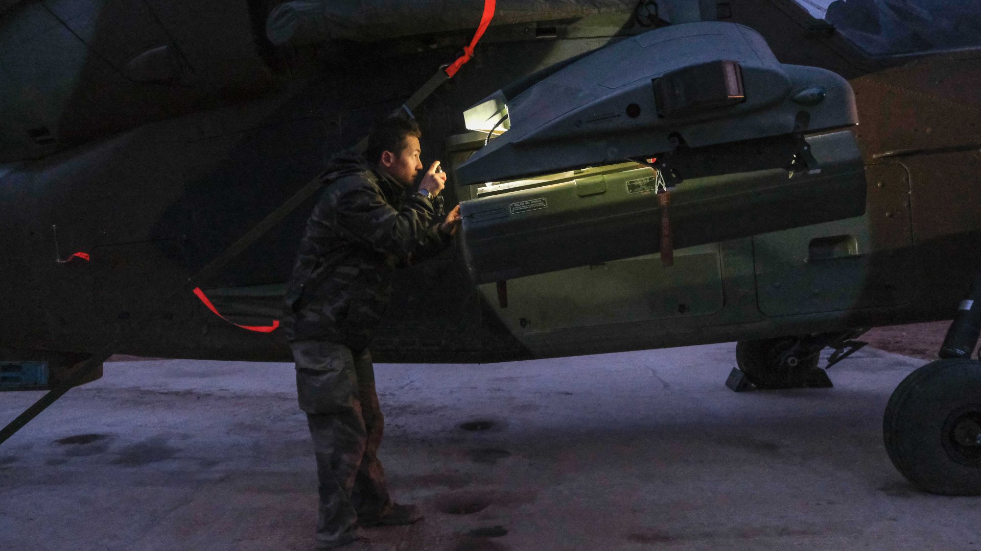 Un maintenancier inspecte l'armement du Tigre au petit matin.