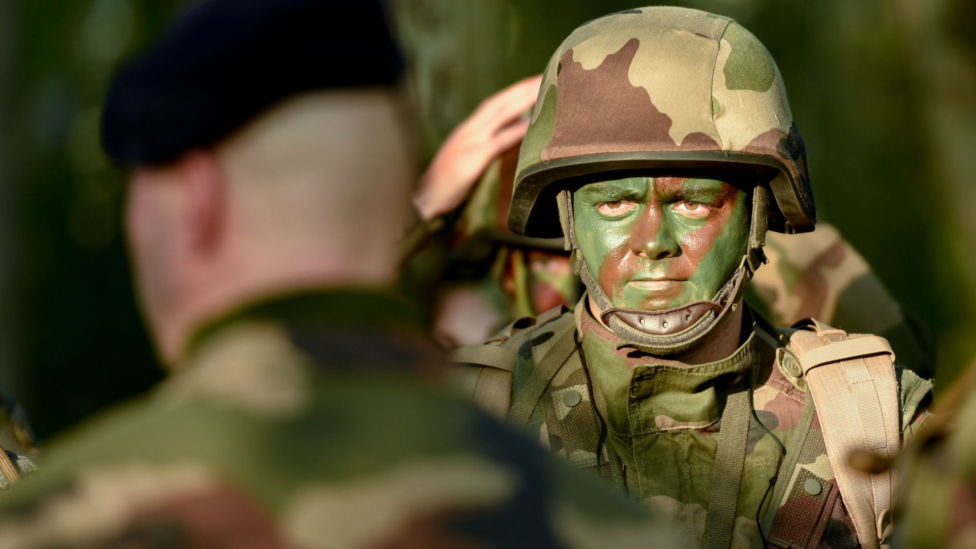 Un soldat est attentif aux ordres donnés par son chef de section avant l'exercice de nuit.