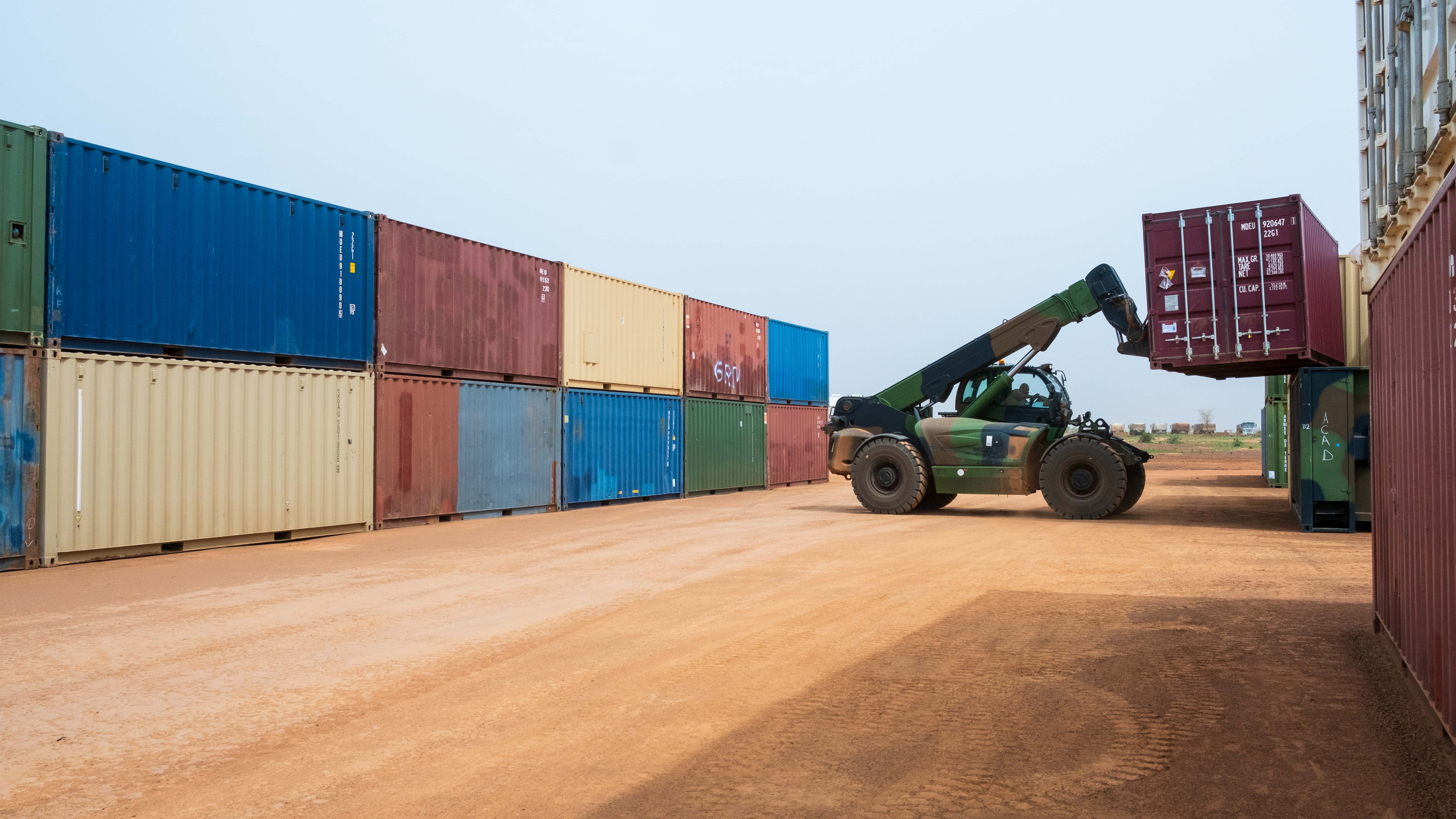 Un chariot élévateur dépose un container dans un HUB logistique.