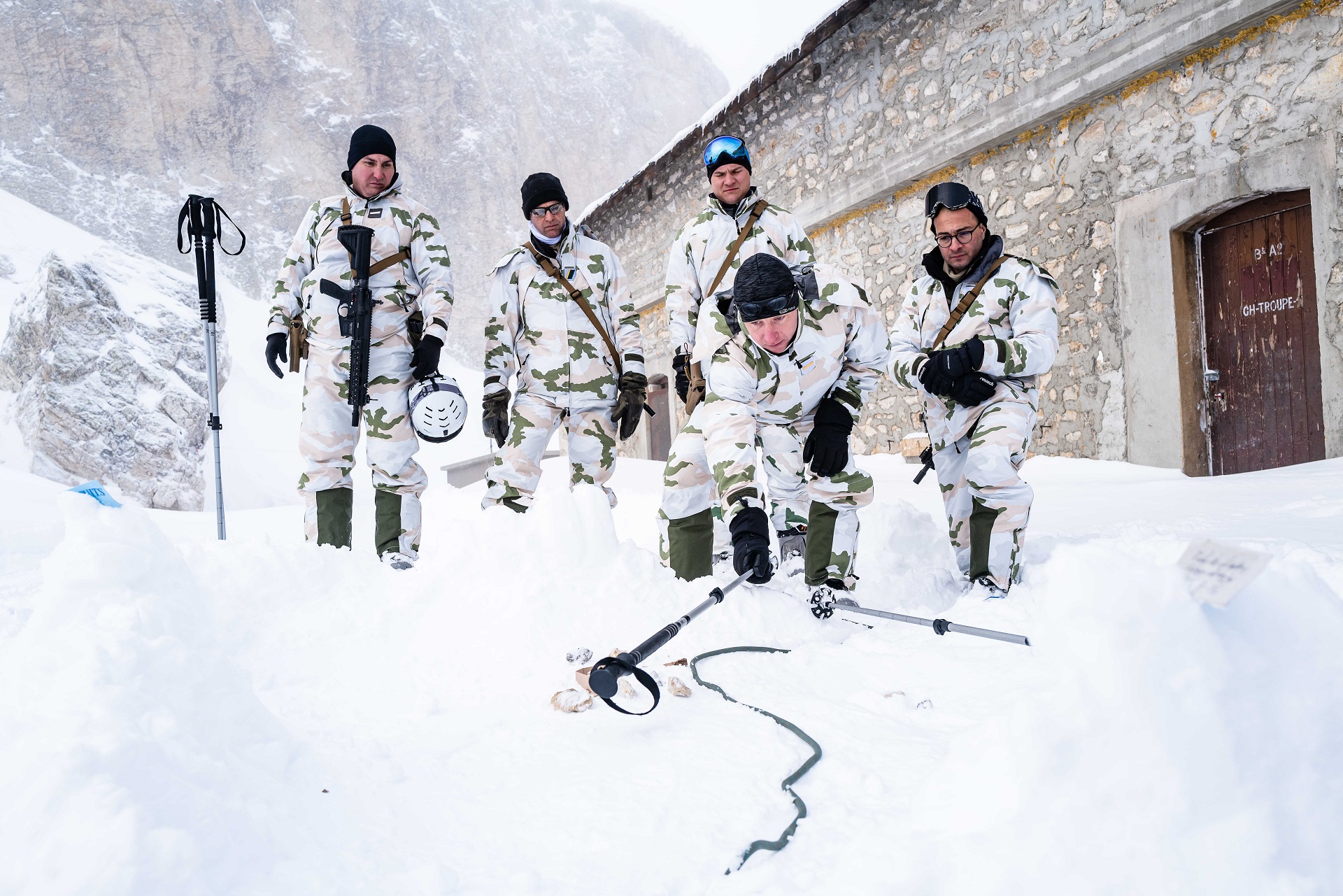 Le chef de section explique la manoeuvre de combat à ses chefs de groupe, à l'aide d'une caisse à sable.