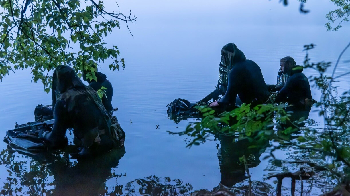 Dans l'eau, les plongeurs attendent d'être rejoints par leurs camarades pour pouvoir se changer. 