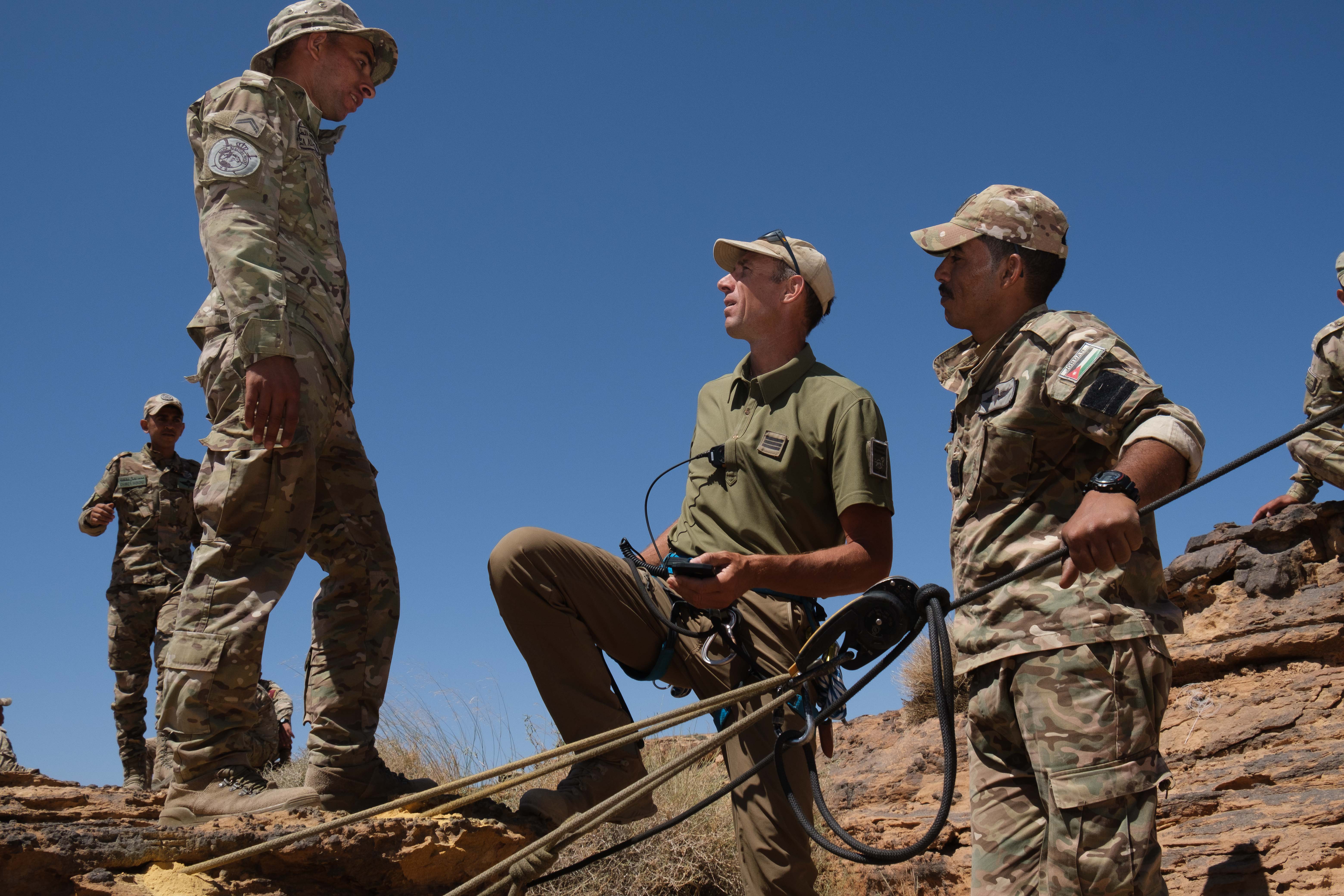 Un officier montagne échange avec les soldats jordaniens sur les techniques pour installer les équipements.