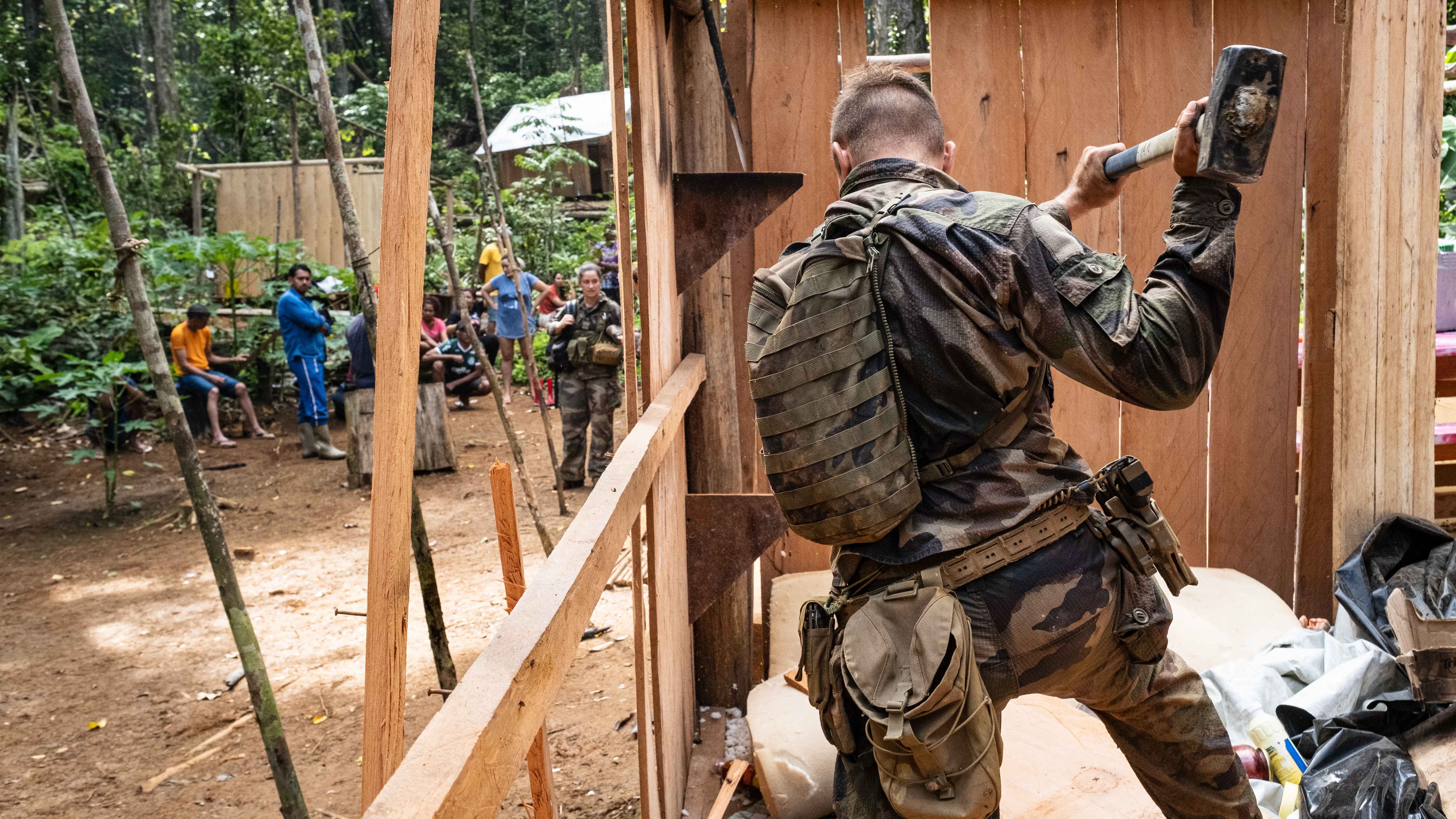 Un soldat français démonte un carbet appartenant aux orpailleurs illégaux, non loin d'un site d'orpaillage clandestin.