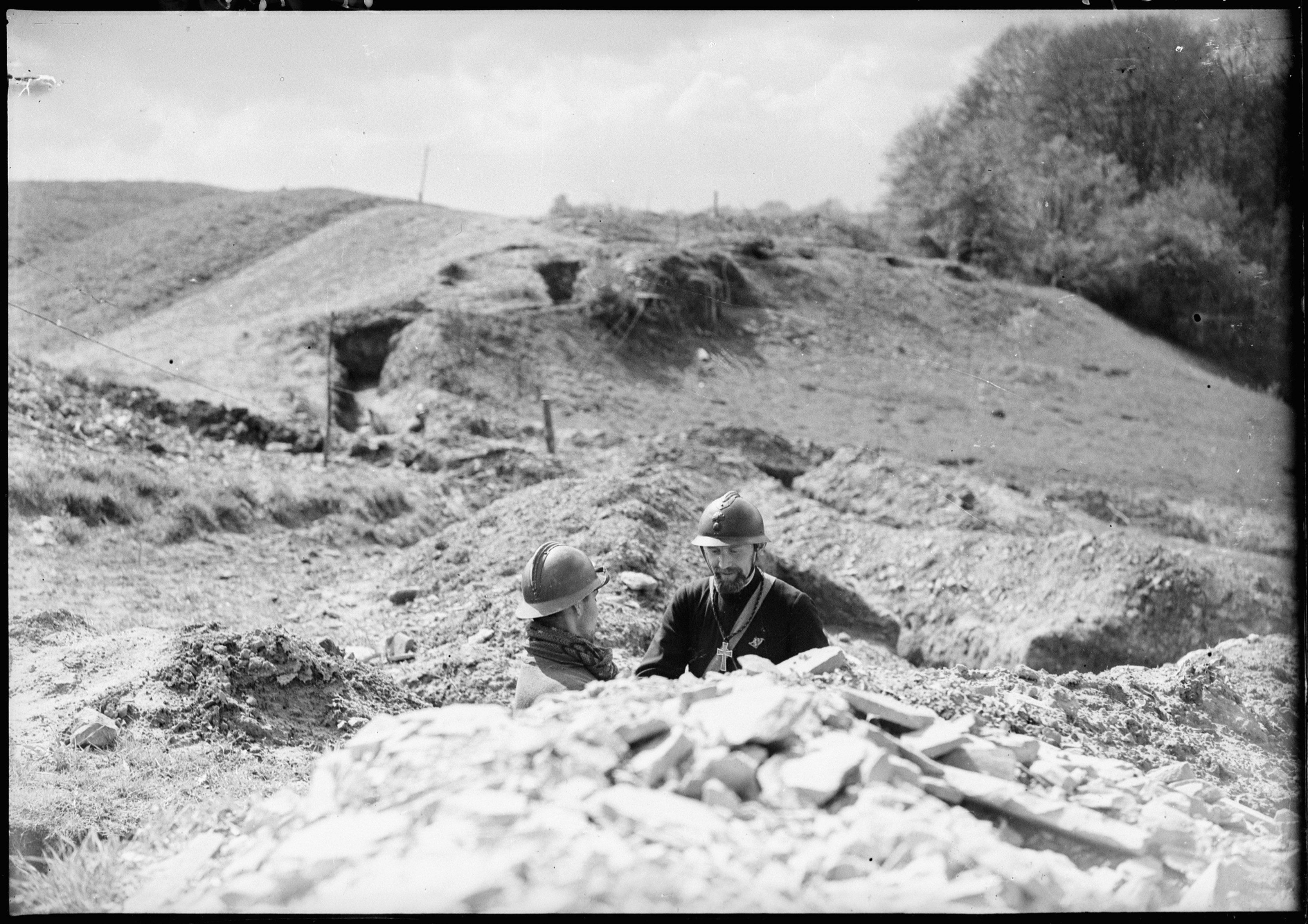 1940, Lorraine : un aumônier discute avec un soldat dans une tranchée.