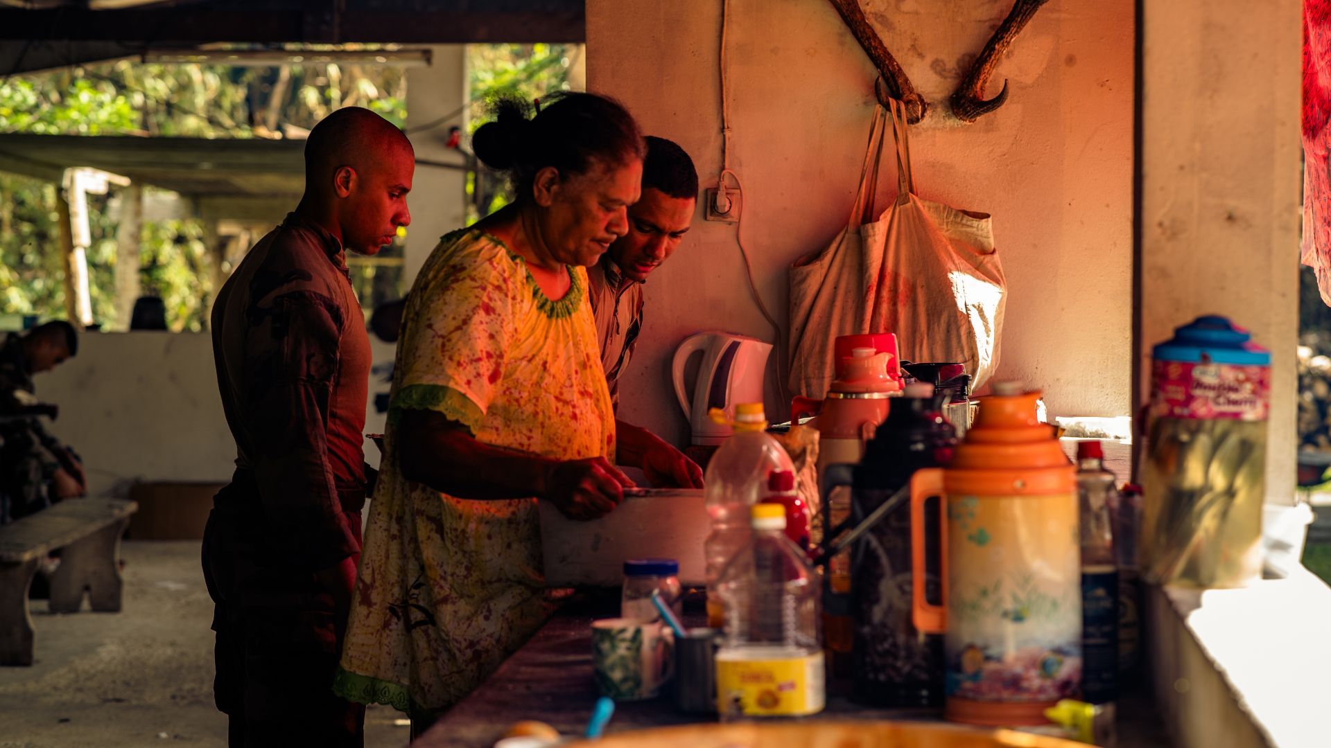 Deux légionnaires assistent une femme de la tribu à préparer les repas.