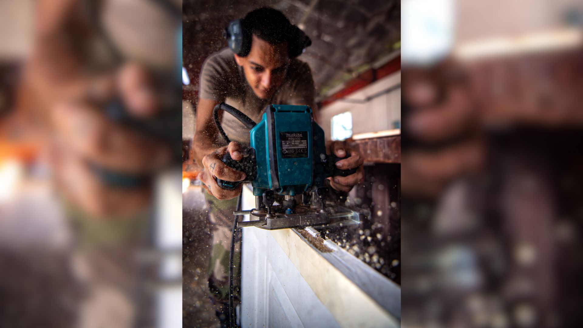 Un jeune volontaire stagiaire de la filière bois manipule une scie circulaire.