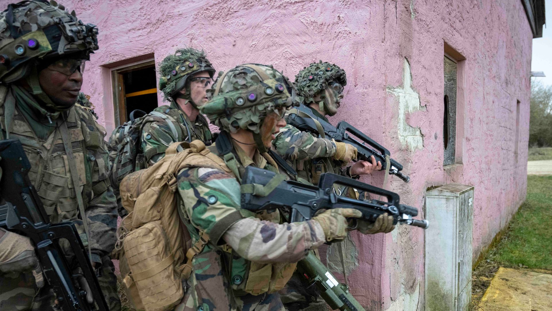 Des snipers sont postés dans la maison opposée. Les Français avancent méthodiquement en sécurisant les bâtiments un à un.