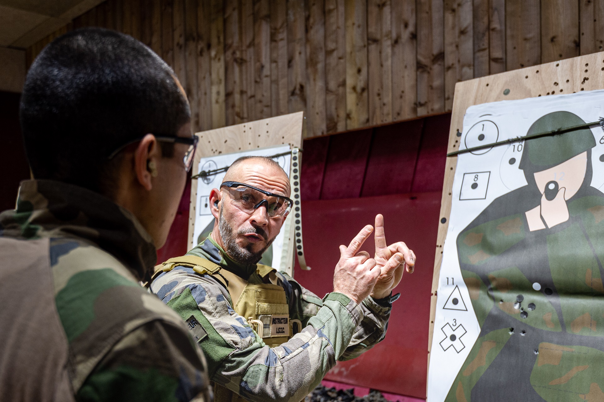 Un instructeur tir conseille un élève-officier