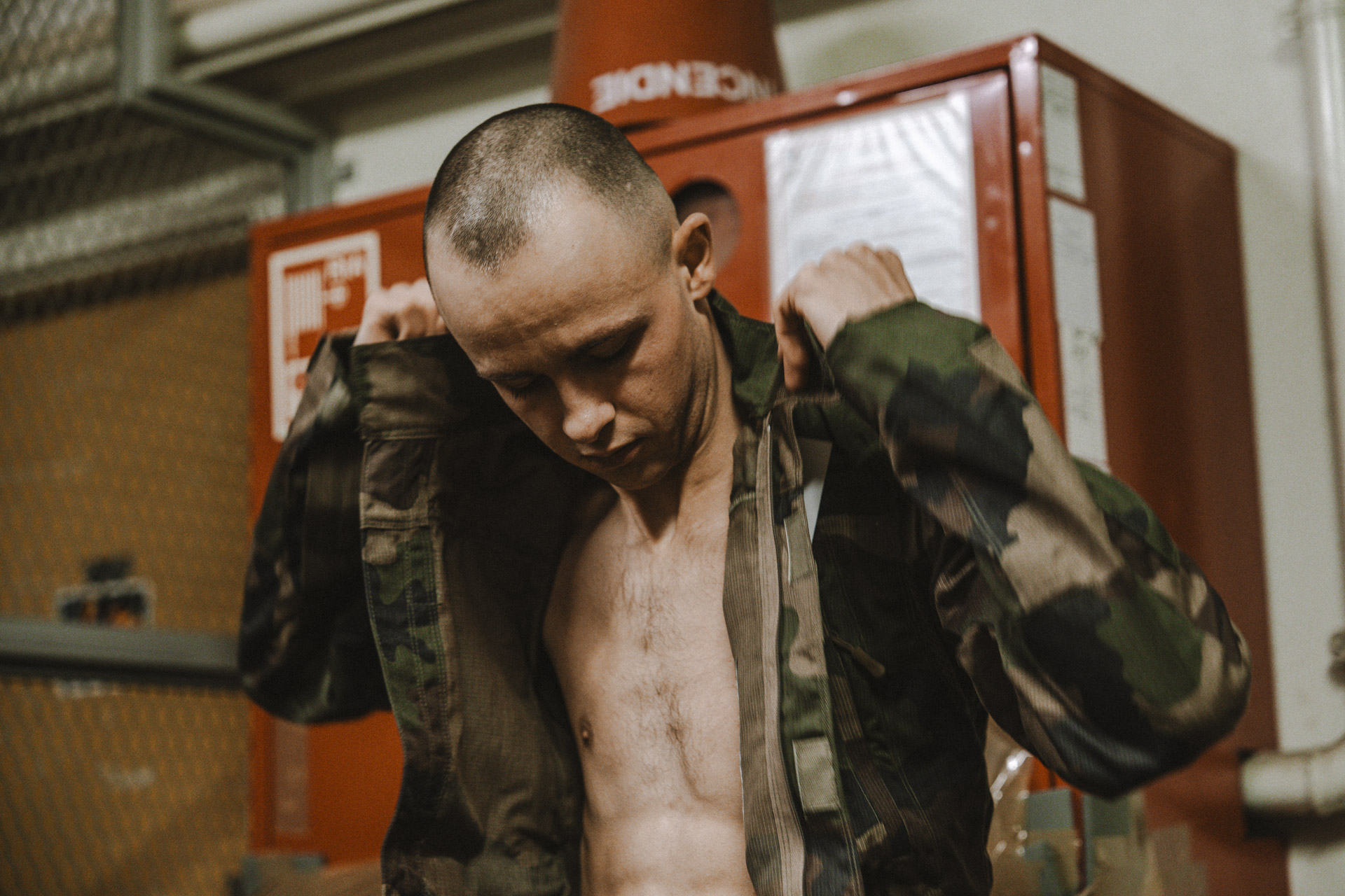 Un jeune soldat essaye sa première veste de treillis.